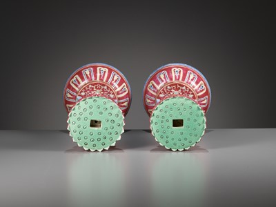 Lot 540 - A PAIR OF LARGE RUBY-GROUND FAMILLE ROSE BUDDHIST EMBLEM ALTAR ORNAMENTS, QING DYNASTY