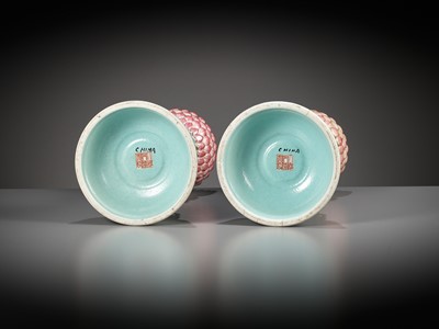 Lot 540 - A PAIR OF LARGE RUBY-GROUND FAMILLE ROSE BUDDHIST EMBLEM ALTAR ORNAMENTS, QING DYNASTY