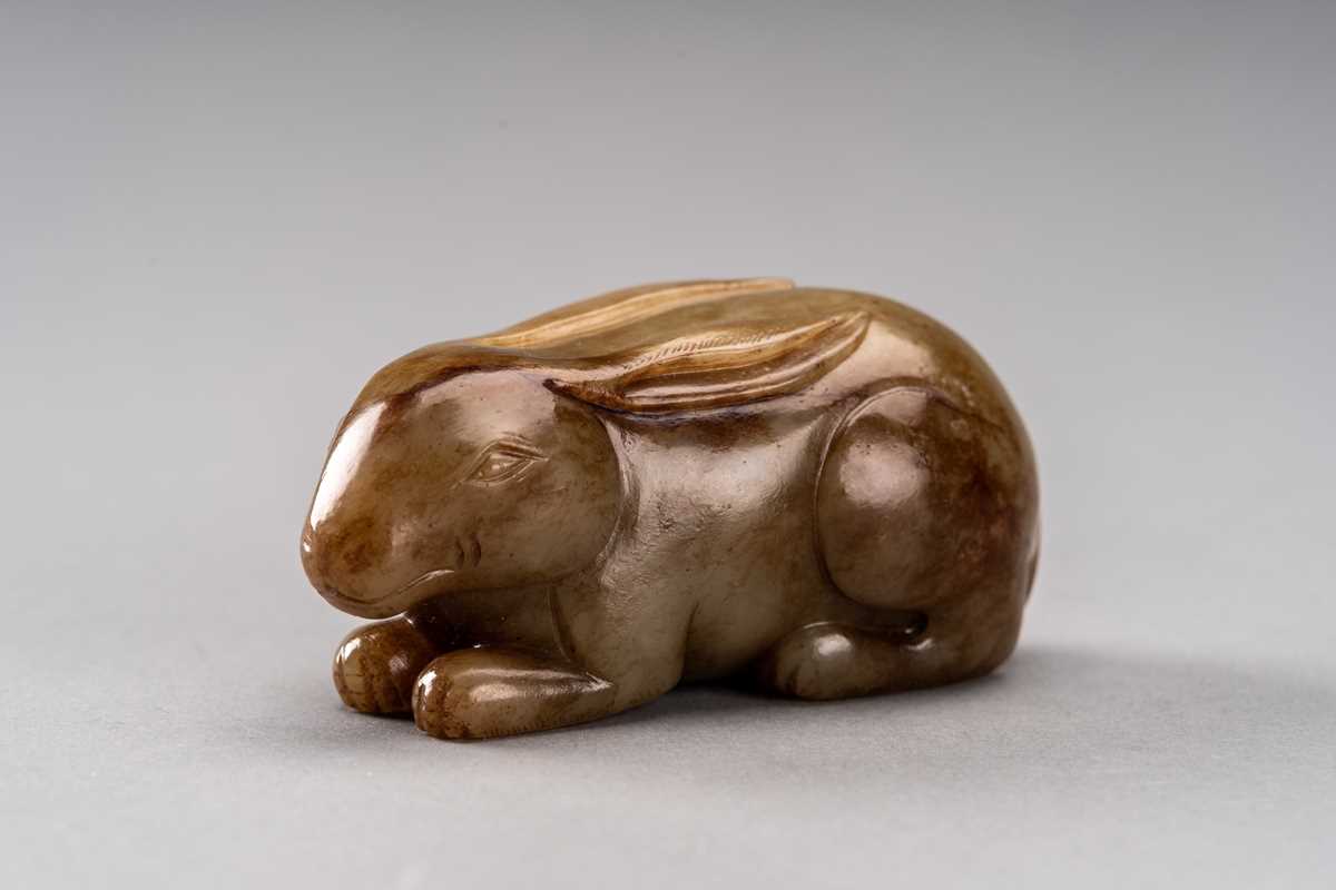 Lot 112 - A CELADON AND RUSSET JADE FIGURE OF A RABBIT,