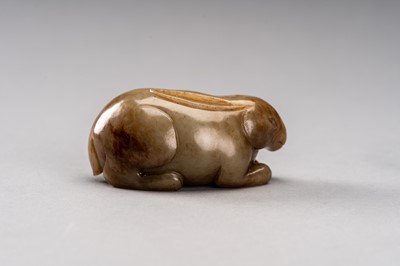 Lot 112 - A CELADON AND RUSSET JADE FIGURE OF A RABBIT, QING