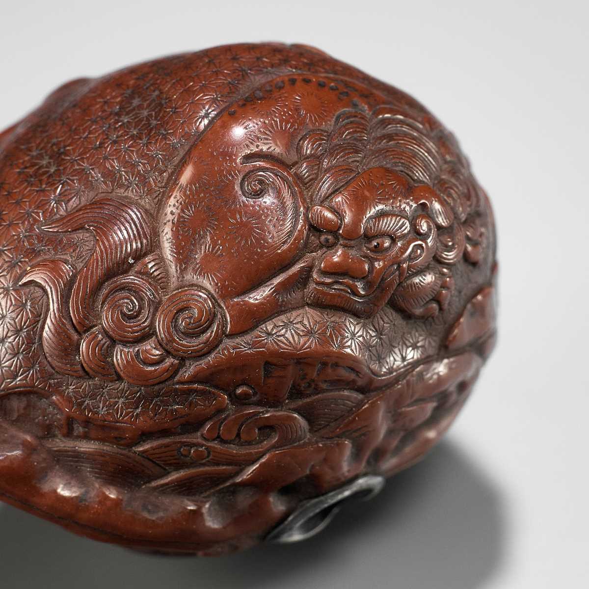 Lot 320 - A VERY FINE KURUMI (WALNUT) NETSUKE WITH SHISHI AND PEONY