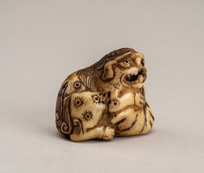 Lot 758 - A STAG ANTLER NETSUKE OF A SHISHI ON A ROCK, EDO PERIOD