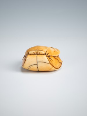 Lot 392 - AN OLD IVORY NETSUKE OF A TEA GRINDER NAPPING BESIDE A MILLSTONE