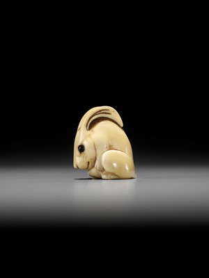 Lot 146 - YOSHINAGA: AN IVORY NETSUKE OF A CROUCHING RABBIT