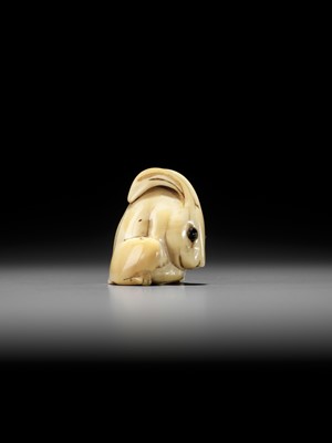 Lot 146 - YOSHINAGA: AN IVORY NETSUKE OF A CROUCHING RABBIT