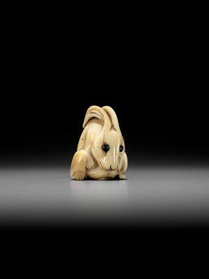 Lot 146 - YOSHINAGA: AN IVORY NETSUKE OF A CROUCHING RABBIT