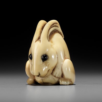 Lot 146 - YOSHINAGA: AN IVORY NETSUKE OF A CROUCHING RABBIT