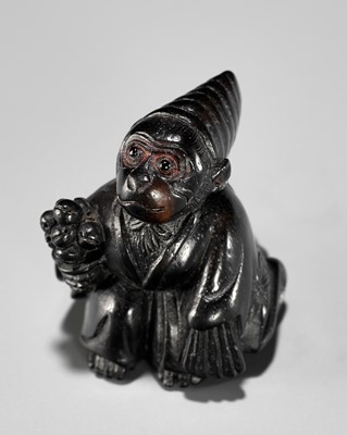 Lot 450 - A CHARMING KUROGAKI (BLACK PERSIMMON) WOOD NETSUKE OF A MONKEY AS A SAMBASO DANCER
