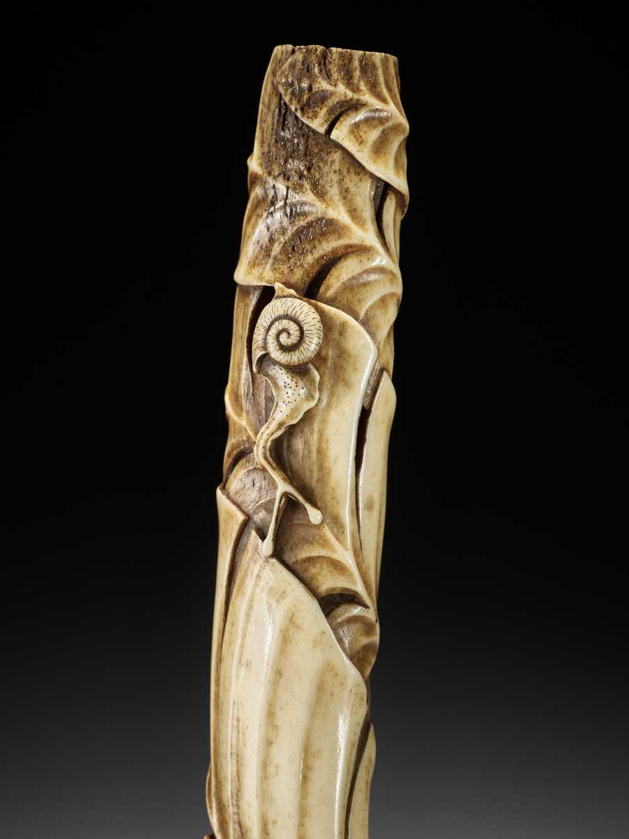 Lot 296 - A FINE ANTLER KISERUZUTSU WITH BASHO LEAVES AND SNAIL