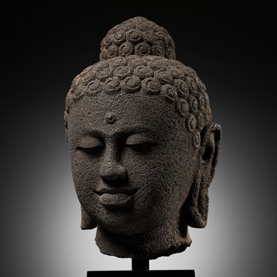 Lot 213 - AN IMPORTANT OVER-LIFESIZE ANDESITE HEAD OF BUDDHA, CENTRAL JAVANESE PERIOD, INDONESIA, 9TH CENTURY