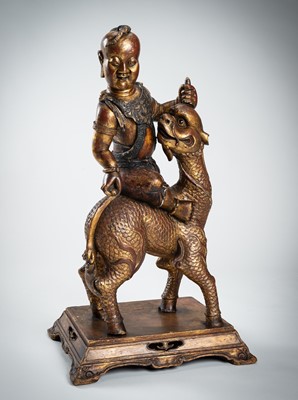 Lot 89 - A VERY LARGE GILT-LACQUERED WOOD STATUE OF YOUNG BUDDHA RIDING QILIN