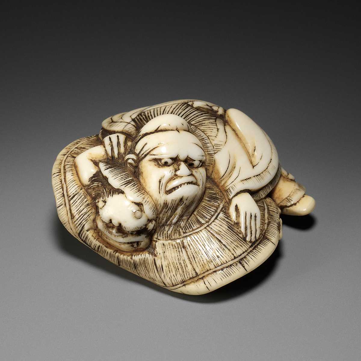 Lot 165 - AN AMUSING OSAKA SCHOOL IVORY NETSUKE OF SHOKI CAPTURING AN ONI, ATTRIBUTED TO HIDEMASA