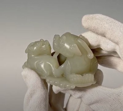 Lot 343 - A PALE CELADON JADE ‘QILIN AND YOUNG’ GROUP, MID-QING DYNASTY