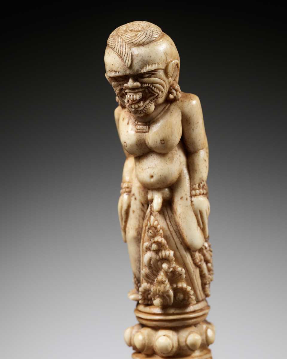 Lot 691 - A CARVED BONE KRIS HILT IN THE FORM OF A MALE DEMON, INDONESIA, 18TH-19TH CENTURY