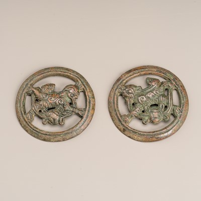 Lot 1003 - A PAIR OF BRONZE HORSE TRACK ‘BUDDHIST LION’ ORNAMENTS, MING OR EARLIER