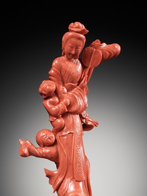 Lot 278 - A CHINESE CARVED RED CORAL FIGURE OF A MEIREN WITH BOYS