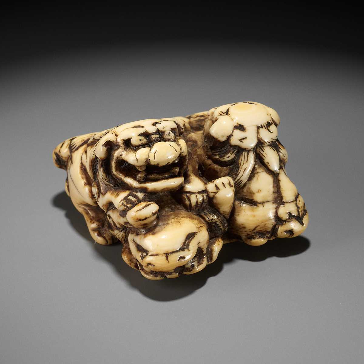 Lot 372 - A FINE IVORY NETSUKE DEPICTING THREE FIGHTING SHISHI