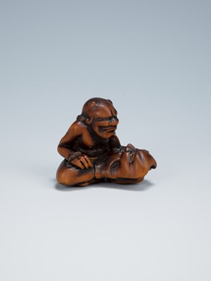 Lot 389 - GYOKKEI: A WOOD NETSUKE OF AN ONI INSPECTING A SHOKI MASK