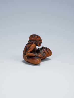 Lot 389 - GYOKKEI: A WOOD NETSUKE OF AN ONI INSPECTING A SHOKI MASK