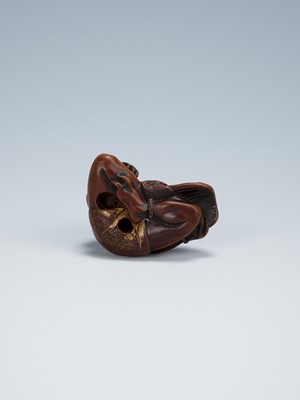 Lot 389 - GYOKKEI: A WOOD NETSUKE OF AN ONI INSPECTING A SHOKI MASK