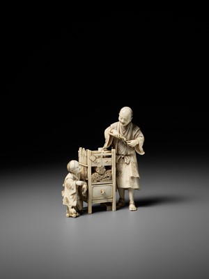 Lot 285 - ICHIYOSAI SOKO: A RARE IVORY OKIMONO DEPICTING A KISERU (PIPE) MAKER WITH HIS SON