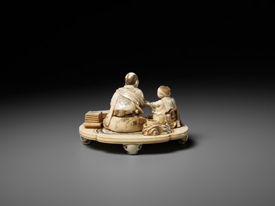Lot 283 - SEISHI: A FINE AND RARE IVORY OKIMONO OF A WOODBLOCK PRINT MAKER WITH HIS SON