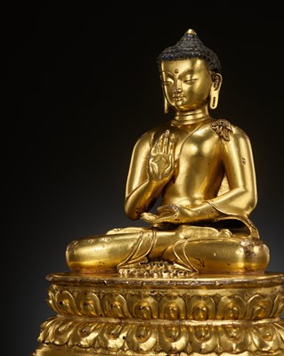 Lot 179 - A GILT COPPER ALLOY FIGURE OF AMOGHASIDDHI, ONE OF THE FIVE WISDOM BUDDHAS, POSSIBLY DENSATIL, TIBET, 14TH-15TH CENTURY