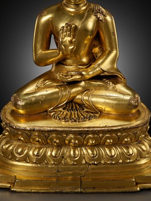 Lot 179 - A GILT COPPER ALLOY FIGURE OF AMOGHASIDDHI, ONE OF THE FIVE WISDOM BUDDHAS, POSSIBLY DENSATIL, TIBET, 14TH-15TH CENTURY