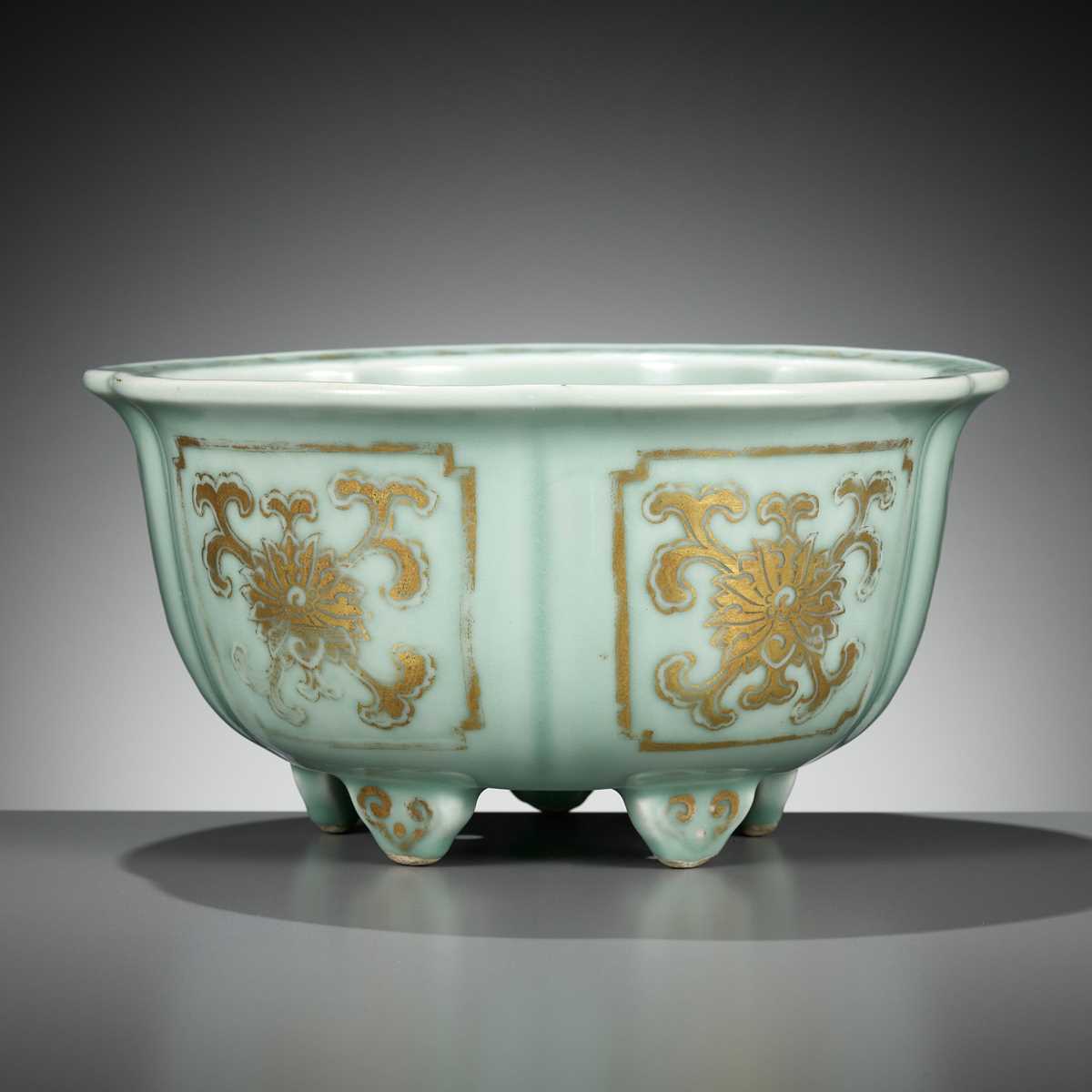 Lot 114 - A MOLDED, LOBED AND GILT CELADON-GLAZED JARDINIÈRE, QIANLONG MARK AND PERIOD