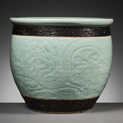Lot 240 - A LARGE MOLDED AND CARVED CELADON-GLAZED ‘DRAGON’ FISHBOWL, QING DYNASTY