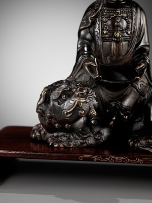 Lot 661 - A BRONZE FIGURE OF WENSHU (MANJUSHRI) ON A LION, LATE MING TO EARLY QING DYNASTY