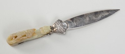 Lot 883 - A PALE CELADON JADE ‘CHILONG’ BELT HOOK MOUNTED IN SILVER AS A LETTER OPENER, 19th CENTURY