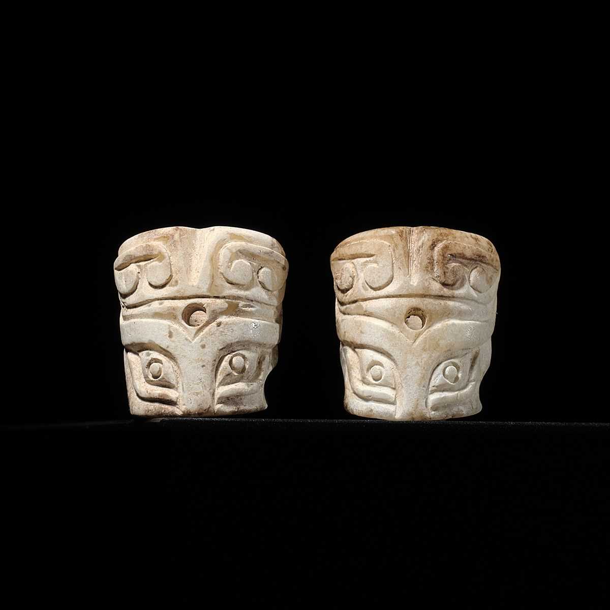 Lot 46 - A PAIR OF CYLINDRICAL ‘TAOTIE MASK’ JADE BEADS, SHANG DYNASTY