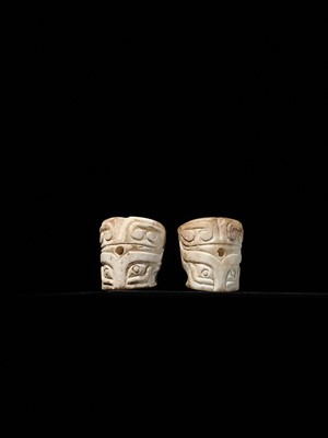 Lot 1010 - A PAIR OF CYLINDRICAL ‘TAOTIE MASK’ JADE BEADS, SHANG DYNASTY