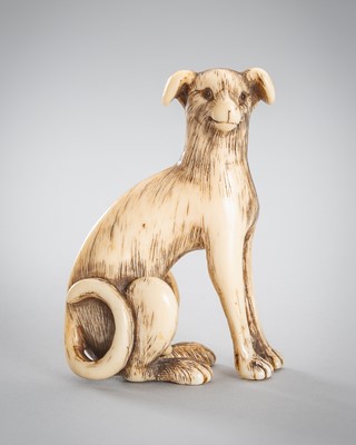 AN IVORY NETSUKE OF A LARGE DOG