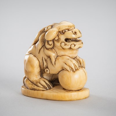 Lot 343 - GYOKUSAI: AN IVORY NETSUKE OF A SHISHI WITH A BALL