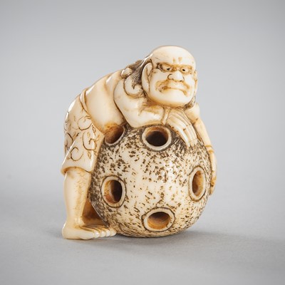 Lot 1557 - A SMALL IVORY NETSUKE OF A MAN WITH A BALL