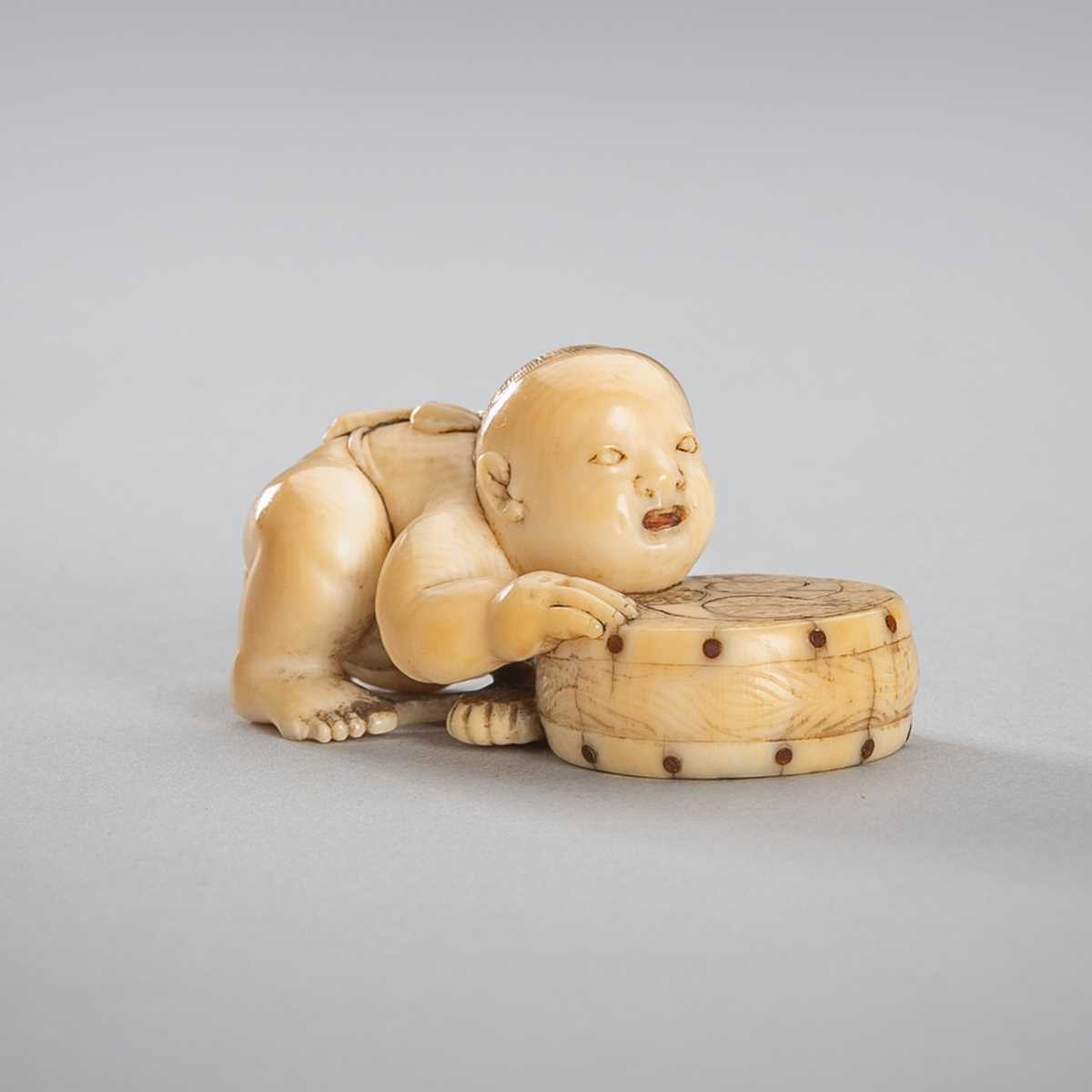 Lot 342 - A SMALL IVORY NETSUKE OF A BOY WITH A DRUM