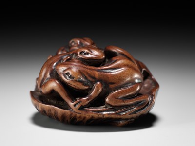 Lot 205 - ISSAN: A FINE WOOD NETSUKE OF SUMO WRESTLING FROGS ON A LOTUS LEAF