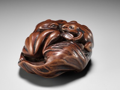 Lot 205 - ISSAN: A FINE WOOD NETSUKE OF SUMO WRESTLING FROGS ON A LOTUS LEAF