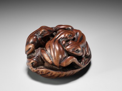 Lot 205 - ISSAN: A FINE WOOD NETSUKE OF SUMO WRESTLING FROGS ON A LOTUS LEAF