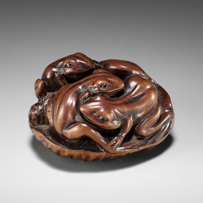 Lot 205 - ISSAN: A FINE WOOD NETSUKE OF SUMO WRESTLING FROGS ON A LOTUS LEAF