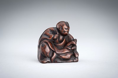 A WOOD NETSUKE OF A YAMABUSHI MONK WITH CONCH