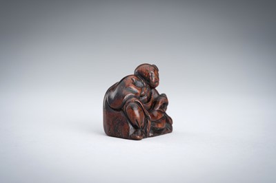 A WOOD NETSUKE OF A YAMABUSHI MONK WITH CONCH