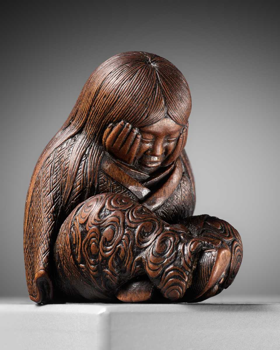 Lot 610 - TADATOSHI: A SUPERB NAGOYA SCHOOL WOOD NETSUKE OF A SLEEPING SHOJO