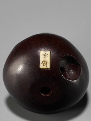 Lot 250 - IPPOSAI: AN AMUSING INLAID IVORY AND WOOD KARAKURI (TRICK) NETSUKE OF A DARUMA DOLL