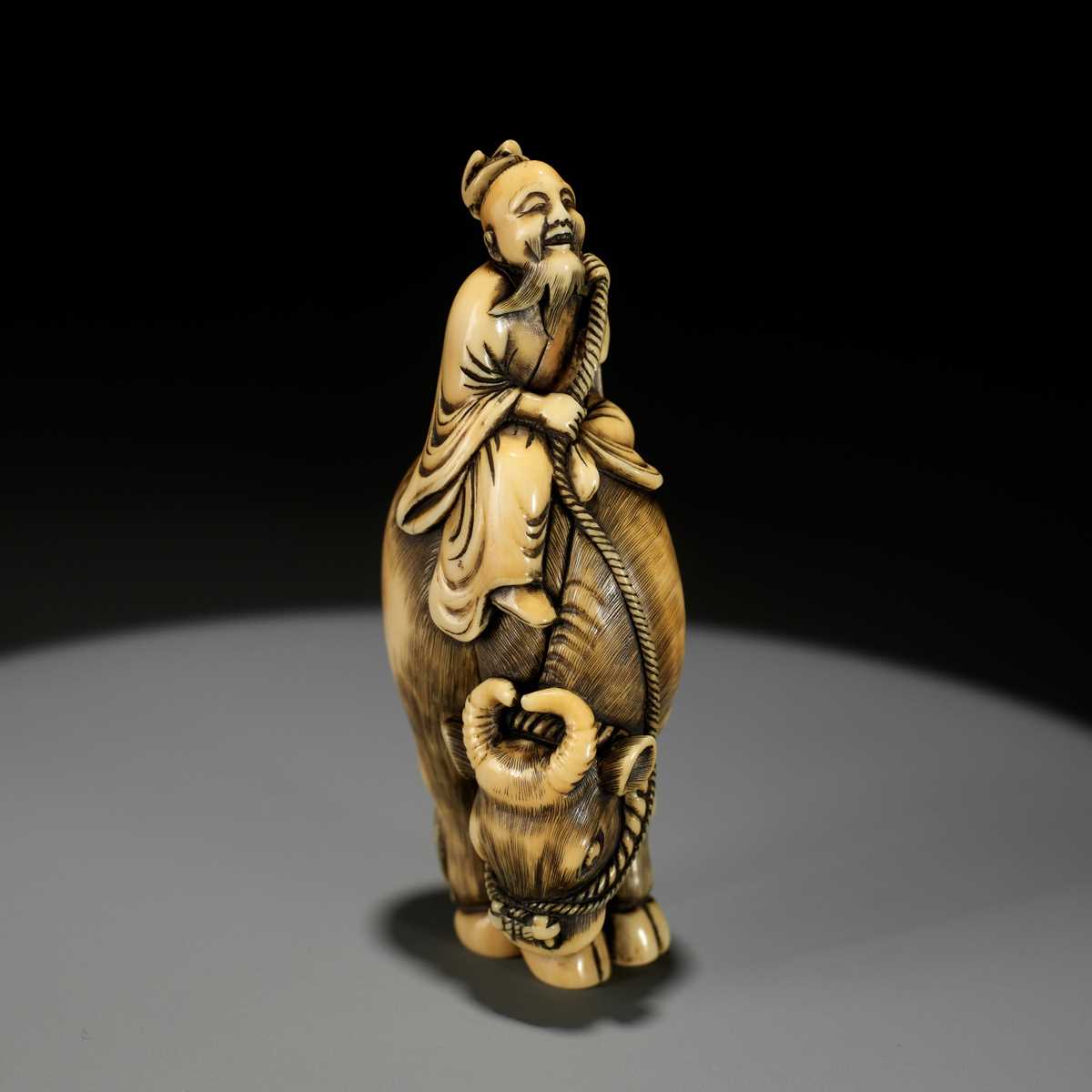 Lot 105 - A FINE IVORY NETSUKE OF ROSHI ON AN OX