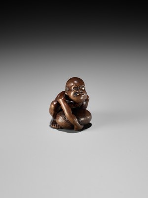 Lot 232 - GYOKUSAI: A FINE WOOD NETSUKE OF A BLIND MASSEUR LIFTING A CHIKARAISHI