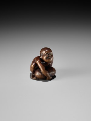 Lot 232 - GYOKUSAI: A FINE WOOD NETSUKE OF A BLIND MASSEUR LIFTING A CHIKARAISHI