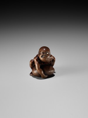 Lot 232 - GYOKUSAI: A FINE WOOD NETSUKE OF A BLIND MASSEUR LIFTING A CHIKARAISHI